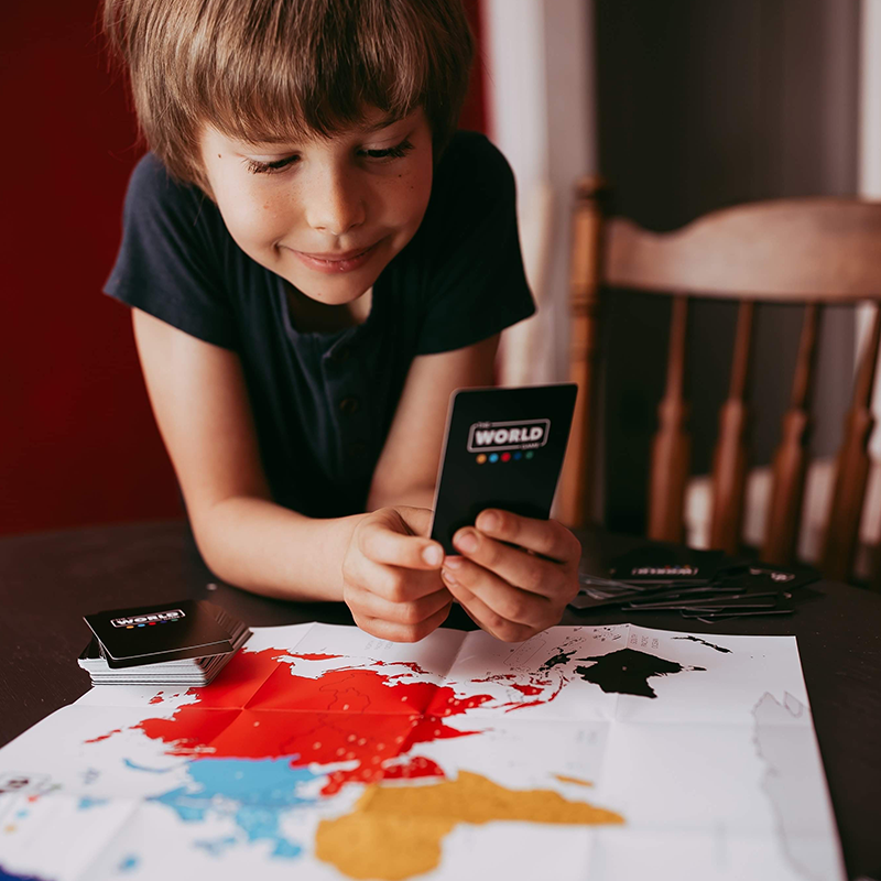 A child playing the world game and learning about continents and geography with his parents at home a great gift for kids