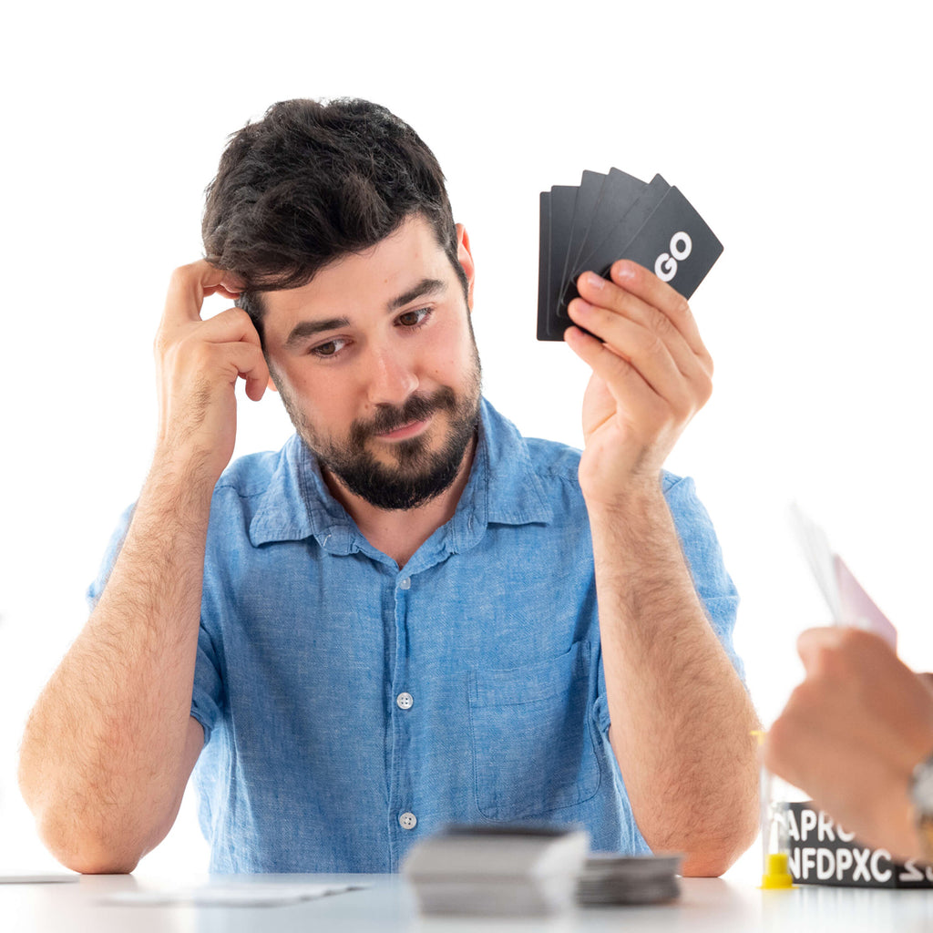 a player thinking about how to play yigo card game and form words with letters in his hand a fun fast game for game nights